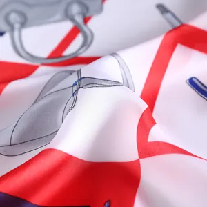 Close-up of silk square scarf showing glossy satin texture and handbag print pattern