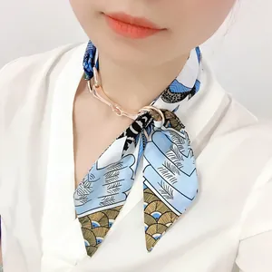 Détail d'un foulard en soie à imprimé plumes avec boucle mors en or rose