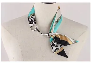 Détail d'un foulard en soie aux motifs de chaînes et léopard avec boucle mors en métal poli
