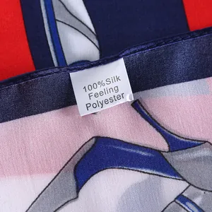 Detail showing the 100% silk feeling polyester label on a printed red satin square scarf