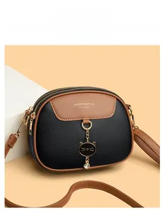 Detail view of semi-circle crossbody bag with litchi texture and gold hardware