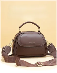 Detailed close-up of dark brown leather texture with embossed logo and golden hardware