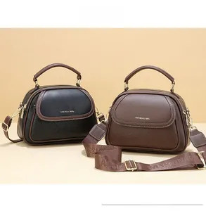 Detail of shell-shaped handbags in black and brown with lychee pattern leather