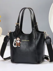 Black litchi grain tote bag with gold lettering and colorful woven wide shoulder strap