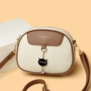 Women's chic round crossbody bag in beige and brown with cat-shaped metal clasp detail