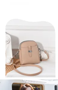 Detail shot of beige pebble leather crossbody phone bag with silver buckle and zipper