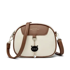 Chic round crossbody phone bag for women with cat pendant and adjustable strap