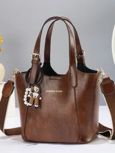 Vintage dark brown leather bucket bag with top handles and a cute cartoon charm