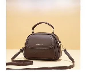 Detailed side view of brown textured leather bag with gold hardware and embossed pattern