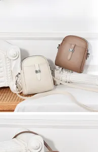 Detail view of premium cowhide mini crossbody bags with lychee texture and metal buckle