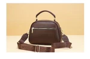 Detail of dark brown litchi pattern leather bag with gold hardware and fashion strap