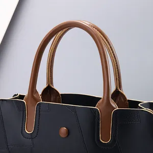 Détail du cuir à motif litchi et de la poignée marron du grand sac cabas