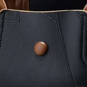 Macro d'un sac en cuir litchi noir avec garniture marron et coutures de detail