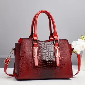 Borsa rossa motivo coccodrillo con finiture dorate e tracolla regolabile