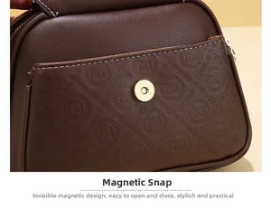 Detail of dark brown leather handbag featuring a gold magnetic buckle and logo embossing