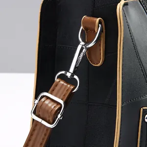 Gros plan du sac en cuir noir à texture géométrique avec mousqueton en métal argenté