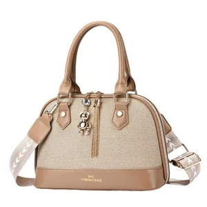 Sac coquille tissé kaki avec garniture en cuir, large bandoulière et pendentif ours