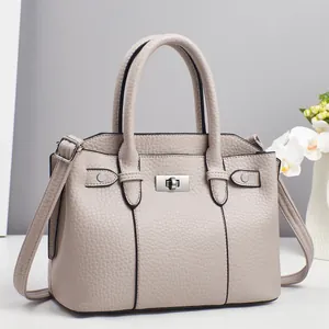 Detail shot of beige lychee texture faux leather bag with silver metal swivel lock clasp