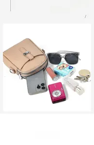 Spacious interior of beige lychee leather crossbody bag with multiple zip pockets