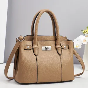 Detail of camel lychee pattern leather handbag with silver twist lock and sturdy handles