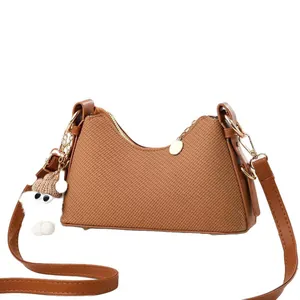Sac bandoulière tressé marron vintage avec un charmant pendentif en peluche