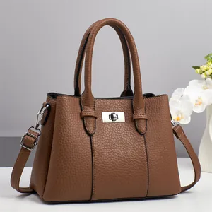 Brown litchi grain leather handbag with silver twist lock and floral accents