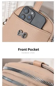 Detail of beige pebble leather phone bag showing front pocket and silver metal zippers
