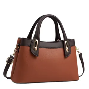 Minimalist caramel brown leather tote bag with contrast handles and golden hardware