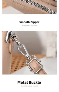 Detail view of smooth metal zipper and adjustable hardware buckle on textured leather bag