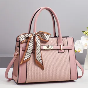 Pink patchwork handbag with woven texture, golden lock, and decorative handle scarf