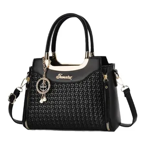 Elegant black woven tote bag with gold hardware and a clover pendant for women