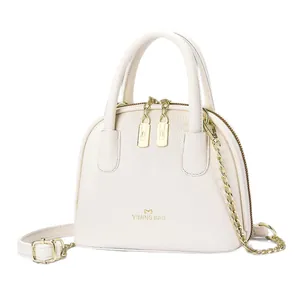 Sac coquille blanc crème avec texture litchi, finitions dorées et bandoulière