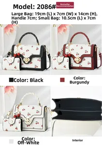 Detail view of cherry print handbag with metal flower clasp and inner compartments