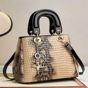 Détail de la texture cuir de crocodile et du pendentif étoile dorée sur le sac à main