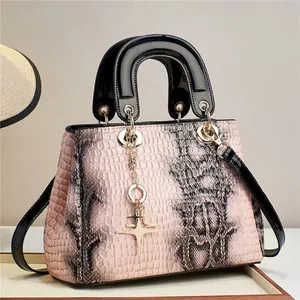 Détail du cuir synthétique serpent rose et gris avec un pendentif étoile doré chic