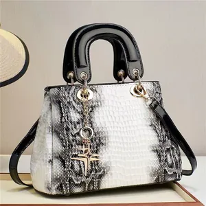 Détail de la texture serpent et du pendentif étoile dorée sur un sac à main trapèze