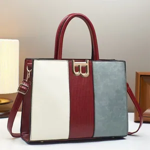 Gros plan détaillé d'un sac à main en cuir tricolore avec boucle dorée en forme de B