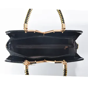 Glossy black faux crocodile handbag interior with woven handle and organized compartments
