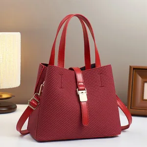 Close-up of luxury red bucket bag with woven texture and premium gold metal hardware