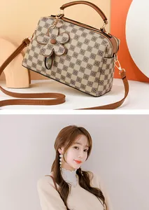 Detail of checkered brown crossbody bag with flower charm and matching rhinestone earrings