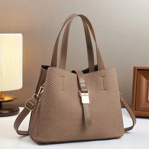 Detailed view of brown woven texture bucket bag with gold buckle and adjustable strap