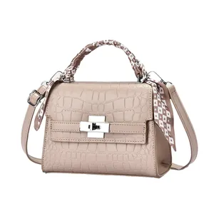 Sac à main beige élégant à motif crocodile avec foulard en soie sur fond blanc neutre