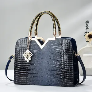 Deep blue faux crocodile leather handbag with gold V-ornament and braided handles