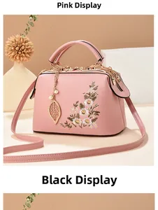 Detailed embroidery of elegant floral patterns on a pink vintage style leather handbag