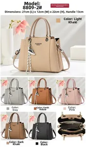 Detail of high-capacity textured handbag with multiple inner pockets and sneaker charm