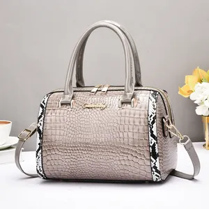 Détail du sac Boston gris à motif crocodile avec bordures serpent et ferrures dorées