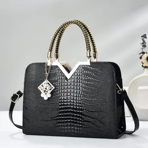 Elegant black crocodile pattern handbag with gold V hardware and woven handle