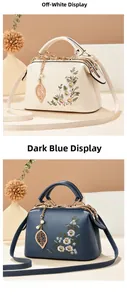 Detail view of beige and dark blue handbags with floral embroidery and leaf pendant
