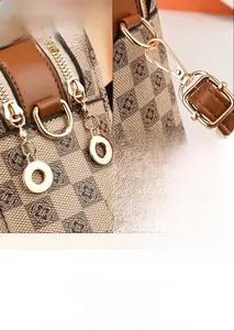 Detail of gold-tone hardware and monogram pattern on a fashion shoulder handbag