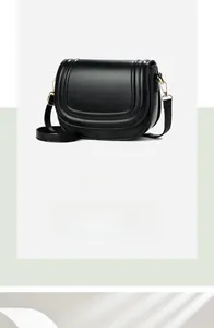Detail of black saddle bag with streamlined edging and gold buckle hardware